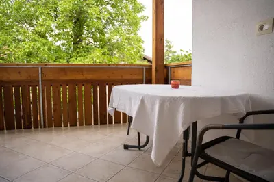 a table with a white table cloth on a balcony at Tribus Lorenz - Wiesgut in Vollan
