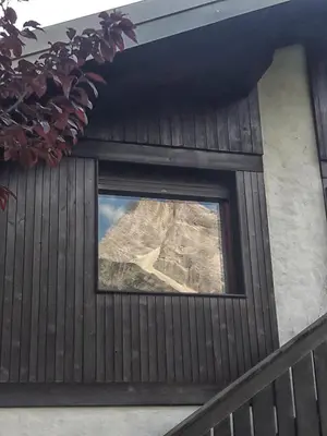 a window in a house with a mountain in the background at Casa Antelao in San Vito di Cadore