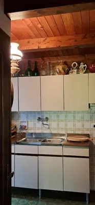 a kitchen with white cabinets and a sink at Casa Antelao in San Vito di Cadore