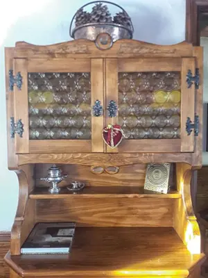 a wooden cabinet filled with lots of wine bottles at Casa Antelao in San Vito di Cadore
