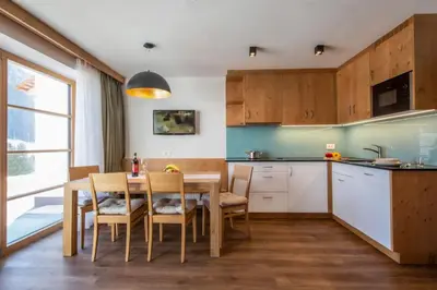 a kitchen with a table and chairs in a room at Apartments Picenin in La Villa