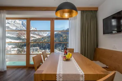 a dining room table with a view of a mountain at Apartments Picenin in La Villa