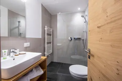 a bathroom with a sink and a toilet and a shower at Apartments Picenin in La Villa