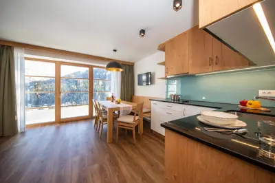 a kitchen with a table and a dining room at Apartments Picenin in La Villa