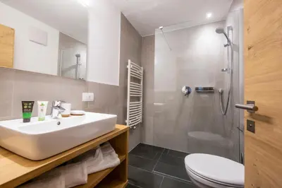 a bathroom with a sink and a toilet and a shower at Apartments Picenin in La Villa