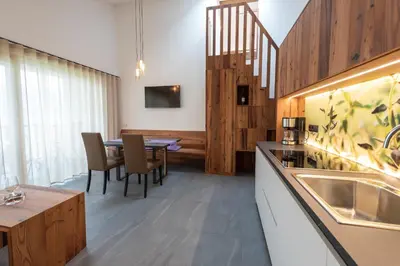 a kitchen with a table and a dining room at Aromis in Termeno