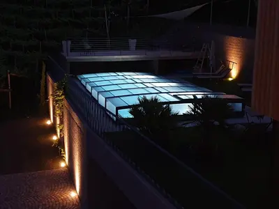 a swimming pool lit up at night with lights at Aromis in Termeno