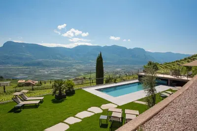 a villa with a swimming pool and a view of mountains at Aromis in Termeno