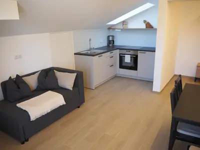 a living room with a couch and a kitchen at Ebner Appartements in Aldino