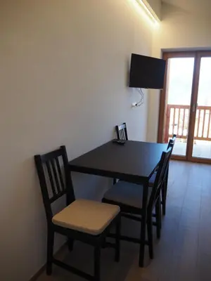 a dining room table with chairs and a television at Ebner Appartements in Aldino