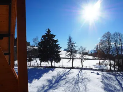 a snow covered yard with the sun in the sky at Ebner Appartements in Aldino