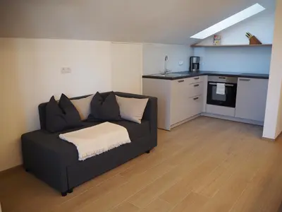 a living room with a couch and a kitchen at Ebner Appartements in Aldino