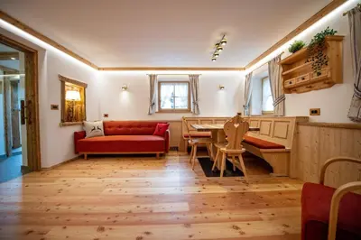 a living room with a red couch and a table at Apartments Berna in Ortisei