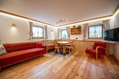 a living room with a red couch and a table at Apartments Berna in Ortisei