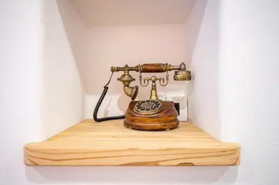 an old telephone is sitting on a wooden shelf at Apartments Berna in Ortisei
