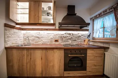 a kitchen with wooden cabinets and a stove top oven at Apartments Berna in Ortisei
