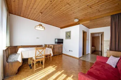 a living room with a table and a couch at Apartments Praruf in Selva di Val Gardena