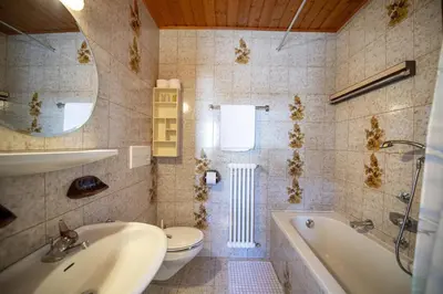 a bathroom with a tub and a toilet and a sink at Apartments Praruf in Selva di Val Gardena