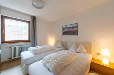 a hotel room with two beds and a window at Casa al Parco Deluxe in Canazei
