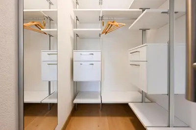 a walk in closet with white cabinets at Casa al Parco Deluxe in Canazei