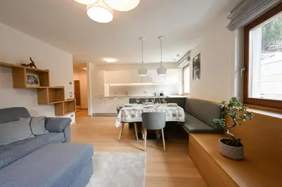 a living room with a couch and a dining room table at Casa al Parco Deluxe in Canazei