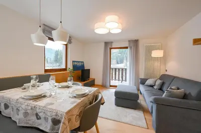 a living room with a table and a couch at Casa al Parco Deluxe in Canazei