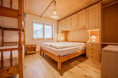 a bedroom with a bed and two bunk beds at Bilocale Fiore in Campitello di Fassa