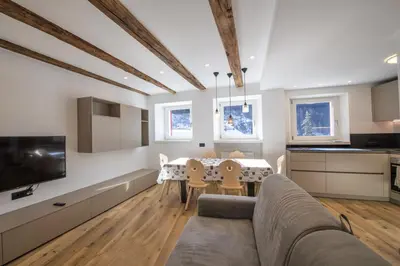 a kitchen and living room with a couch and a table at Dolomites Apartments Cesa Benedet in Santa Cristina in Val Gardena