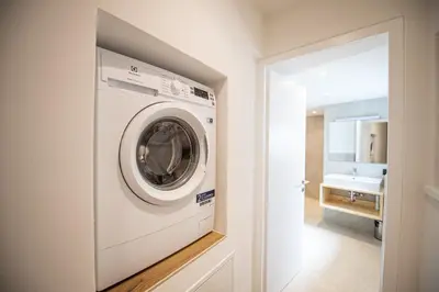 a white washing machine in a bathroom with a sink at Dolomites Apartments Cesa Benedet in Santa Cristina in Val Gardena
