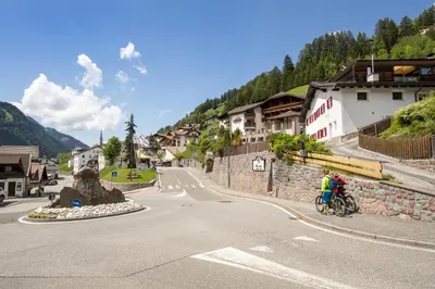 a group of people riding bikes down a street at Dolomites Apartments Cesa Benedet in Santa Cristina in Val Gardena