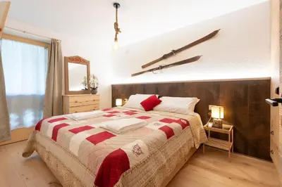 a bedroom with a large bed with a cross on the wall at Ciasa de Chica in Pozza di Fassa