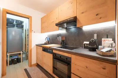a kitchen with wooden cabinets and a sink at Ciasa de Chica in Pozza di Fassa