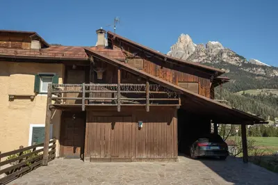 a barn with a car parked outside of it at Ciasa de Chica in Pozza di Fassa