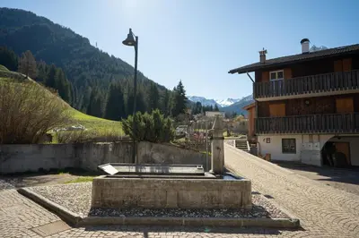 a water fountain in the middle of a street at Ciasa de Chica in Pozza di Fassa