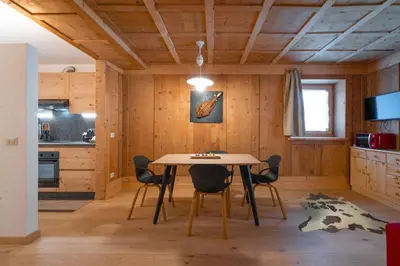 a kitchen and dining room with a table and chairs at Ciasa de Chica in Pozza di Fassa