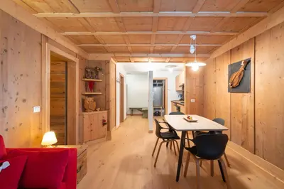 a room with wooden walls and a table and chairs at Ciasa de Chica in Pozza di Fassa