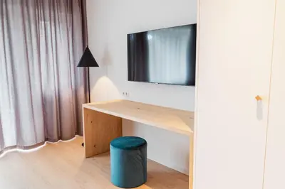 a room with a desk with a tv and a stool at Villa Kranebitt in Bressanone