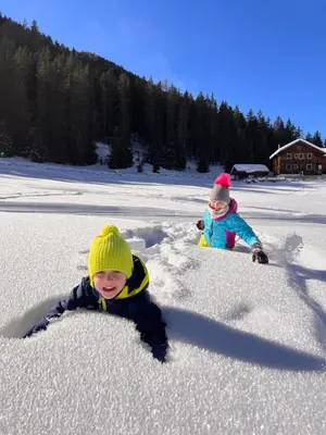 two children are playing in the snow at Villa Kranebitt in Bressanone