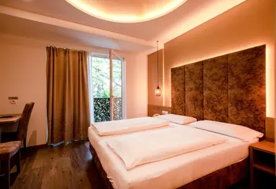 a bedroom with a large bed with a large window at Hotel Chrys in Bolzano