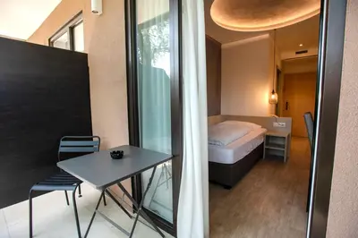 a small room with a bed and a table at Hotel Chrys in Bolzano