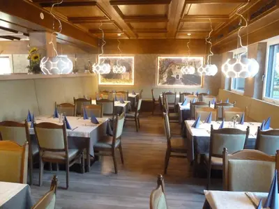 a dining room filled with tables and chairs at Hotel Chrys in Bolzano