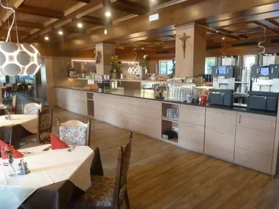 a restaurant with two tables and a large kitchen at Hotel Chrys in Bolzano