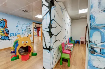 two pictures of a play room with a mural at Hotel Club Regina E Fassa in Mazzin
