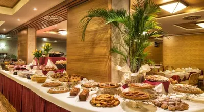 a long table filled with different types of food at Hotel Club Regina E Fassa in Mazzin
