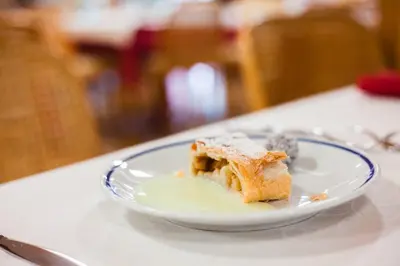 a piece of cake on a plate on a table at Hotel Club Regina E Fassa in Mazzin
