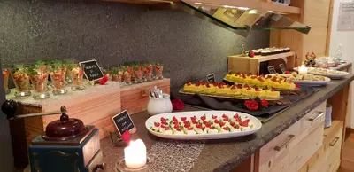 a buffet with many different types of desserts on a counter at Hotel Azola in Canazei