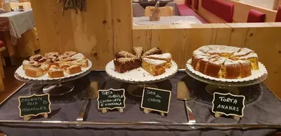 a table with different types of cakes on display at Hotel Azola in Canazei