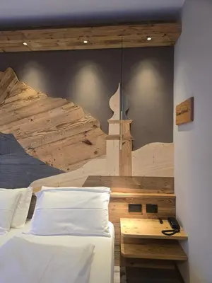 a bedroom with two beds and a mural of a mountain at Hotel Azola in Canazei