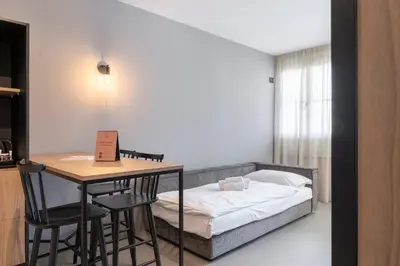 a bedroom with a bed and a table and chairs at Residence - Palais Hörtenberg in Bolzano