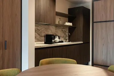 a dining room with a table and a kitchen at Residence - Palais Hörtenberg in Bolzano